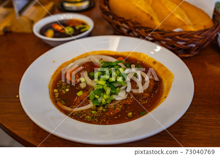 Plate of Vietnamese stewed beef brisket soup served with bread 73040769