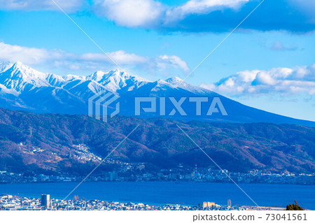 Snow-capped Yatsugatake mountain range and Lake Suwa [Nagano Prefecture] 73041561