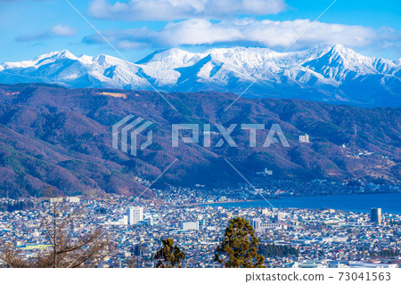 Snow-capped Yatsugatake mountain range and Lake Suwa [Nagano Prefecture] 73041563