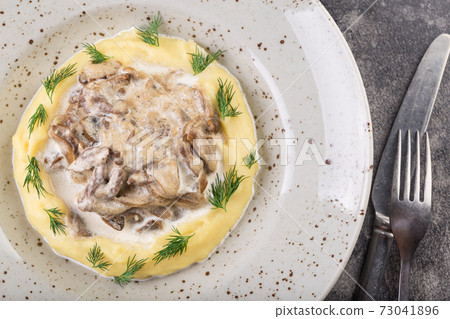 Beef stroganoff with mashed potatoes in a white plate with cutlery. Photo for menu. 73041896