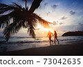 Teenage couple running on the beach 73042635