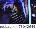 Asian young girl using a mobile phone in downtown 73042646