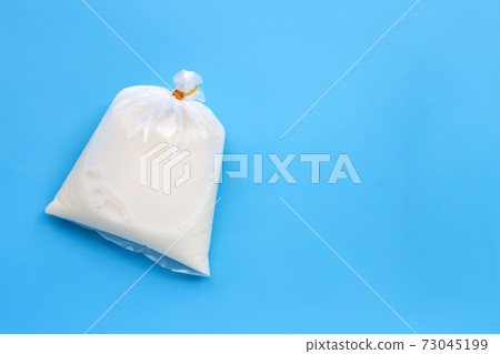 Soymilk in plastic bag on blue background. Top view Soymilk in plastic bag on blue background. Top view 73045199