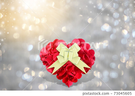 Rose petals heart shape with golden gift bow on background bokeh 73045605