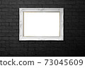 white frame on black brick wall 73045609
