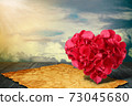 heart shape made out of rose petals with old paper on wooden deck table 73045680
