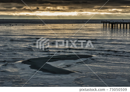 A sand bar with a beautiful ocean sunset in the background. Photo from Hallevik, Blekinge, Sweden 73050509