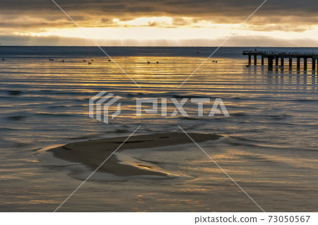 A sand bar with a beautiful ocean sunset in the background. Photo from Hallevik, Blekinge, Sweden 73050567