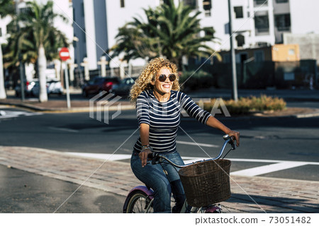 Cheerful people caucasian woman smile and enjoy bike ride in outdoor leisure activity in the city - active female have fun and have active lifestyle transportation concept free 73051482
