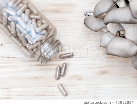 mushrooms and a bottle with mushroom capsules supplement 73051894