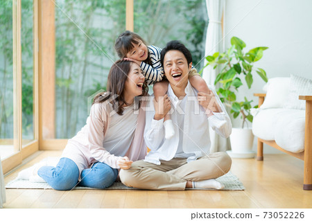 一個三口之家的肖像，一個女孩坐在客廳裡，被她的父親嘲笑 73052226