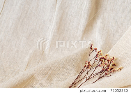 Dry yellow flower on natural cotton fabric background with copyspace Dry yellow flower on natural cotton fabric background with copyspace 73052280