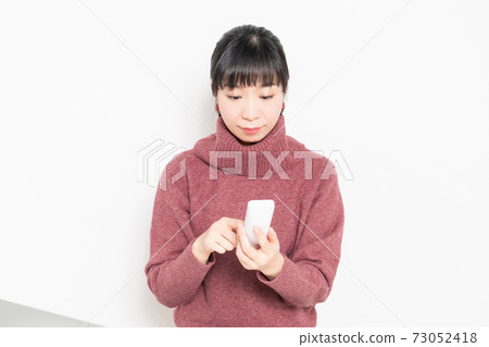 Woman holding a telephone handset Woman holding a telephone handset 73052418