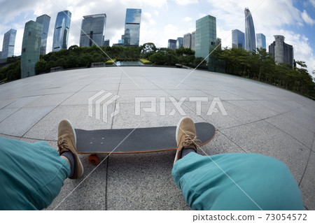 Asian woman skateboarder with skateboard in modern city Asian woman skateboarder with skateboard in modern city 73054572