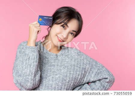People material of a young young female model holding a credit card 73055059
