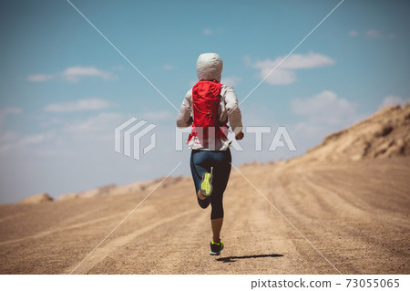 Fitness woman trail runner cross country running on sand desert dunes Fitness woman trail runner cross country running on sand desert dunes 73055065