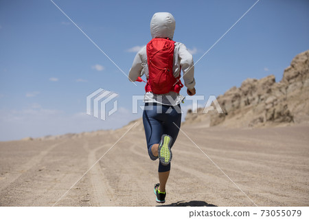 Fitness woman trail runner cross country running on sand desert dunes Fitness woman trail runner cross country running on sand desert dunes 73055079
