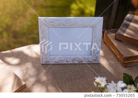 Photo frame surrounded by objects at a wedding Photo frame surrounded by objects at a wedding 73055203