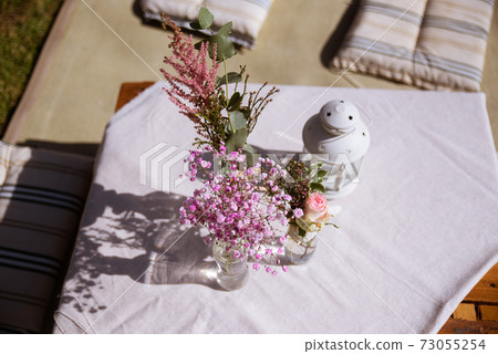 Outdoors wedding decoration with flowers and a lantern Outdoors wedding decoration with flowers and a lantern 73055254