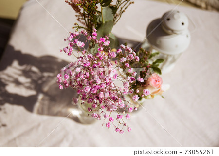 Outdoors wedding decoration with flowers and a lantern Outdoors wedding decoration with flowers and a lantern 73055261
