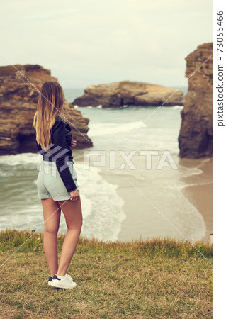 Young woman on the Cathedrals beach (Aguasantas) with high tide in Ribadeo, Spain Young woman on the Cathedrals beach (Aguasantas) with high tide in Ribadeo, Spain 73055466