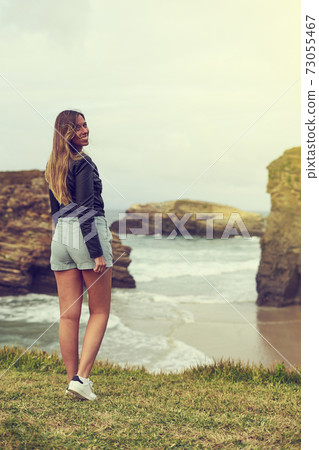 Young woman on the Cathedrals beach (Aguasantas) with high tide in Ribadeo, Spain Young woman on the Cathedrals beach (Aguasantas) with high tide in Ribadeo, Spain 73055467