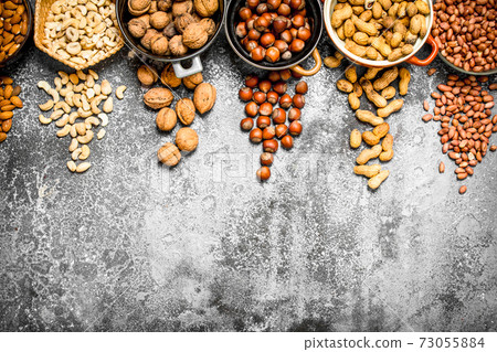 A lot of nuts in different bowls. A lot of nuts in different bowls. 73055884