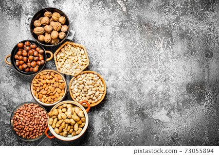 A lot of nuts in different bowls. 73055894