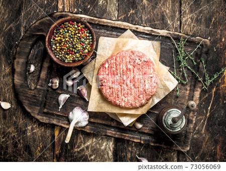 Raw burger with spices and herbs. Raw burger with spices and herbs. 73056069