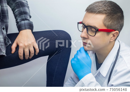 A woman suffers from pain in the inner thigh. The concept of treating a hip joint for trauma, myositis, impaired nerve endingsor osteoarthritis. The doctor examines 73056148