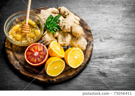 Fresh ginger with honey and lemons on the Board. Fresh ginger with honey and lemons on the Board. 73056451