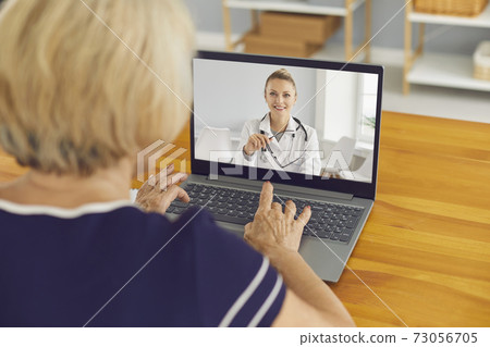 Senior woman sitting at laptop and talking to virtual doctor of e-health service 73056705