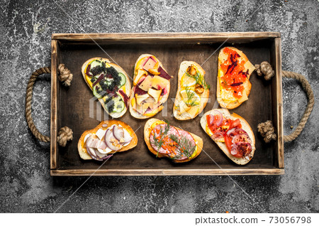 Sandwiches with meat, salami, seafood and fresh vegetables. Sandwiches with meat, salami, seafood and fresh vegetables. 73056798