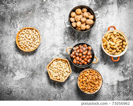 A lot of nuts in different bowls. 73056962