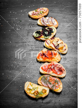 Fresh sandwiches from seafood with salmon, caviar, bacon and vegetables. Fresh sandwiches from seafood with salmon, caviar, bacon and vegetables. 73057089