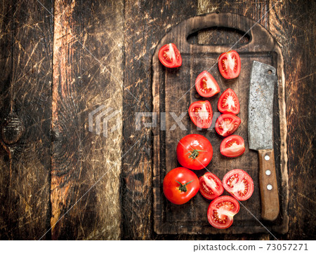 Fresh tomatoes with old hatchet on a chopping Board. 73057271