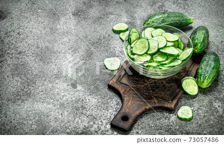 Slices of fresh cucumbers in a bowl. Slices of fresh cucumbers in a bowl. 73057486
