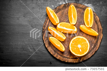 Pieces of ripe oranges on the Board. Pieces of ripe oranges on the Board. 73057501