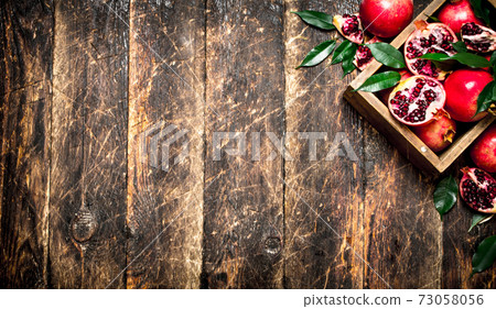 Fresh pomegranates in an old box. 73058056