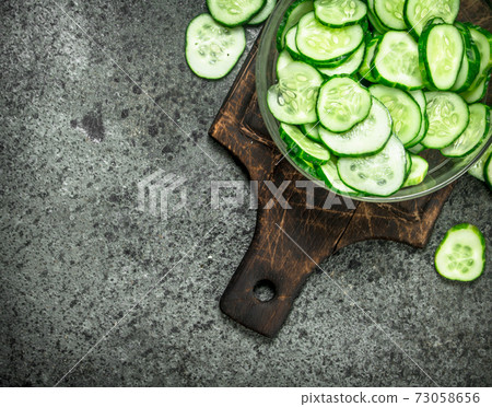 Slices of fresh cucumbers in a bowl. Slices of fresh cucumbers in a bowl. 73058656