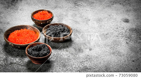 Red and black caviar in wooden bowls. 73059080