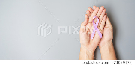 World cancer day (February 4). Woman hand hoy Lavender purple ribbon for supporting people living and illness. Healthcare and medical concept World cancer day (February 4). Woman hand hoy Lavender purple ribbon for supporting people living and illness. Healthcare and medical concept 73059172