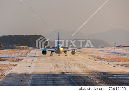 一架飛機沿著冰雪覆蓋的導軌飛向跑道 一架飛機沿著冰雪覆蓋的導軌飛向跑道 73059433