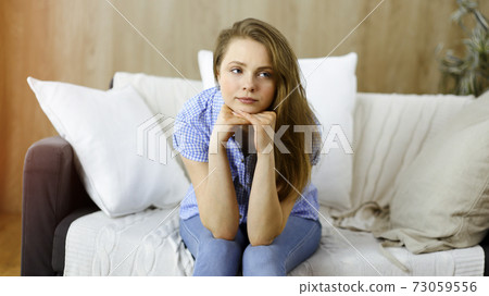 Tired upset woman worried about tiredness from domestic work and self isolation quarantine for COVID-19 Coronavirus 73059556