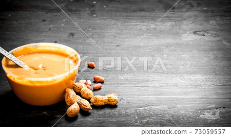 Peanut butter with nuts in a bowl. 73059557