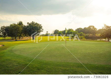 Beautiful golf course in a sunny day. Background evening golf course has sunlight shining down. Golf course in the countryside Beautiful golf course in a sunny day. Background evening golf course has sunlight shining down. Golf course in the countryside 73061028