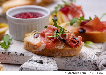 Toasts with pear and prosciutto Toasts with pear and prosciutto 73061367
