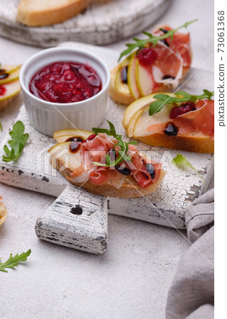 Toasts with pear and prosciutto Toasts with pear and prosciutto 73061368
