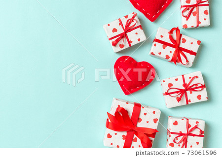Holiday composition of gift boxes and red textile hearts on colorful background with empty space for your design. Top view of Valentine's Day concept 73061596