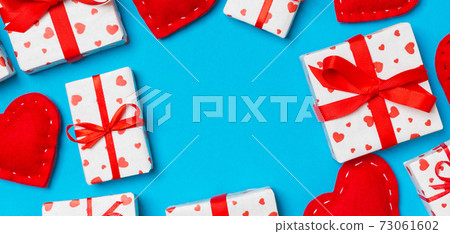 Top view of festive gift boxes and red textile hearts on colorful background with copy space. St Valentine's day concept 73061602